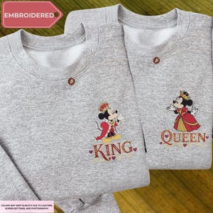 two gray sweatshirts with embroidered characters on them, including a king and a queen.