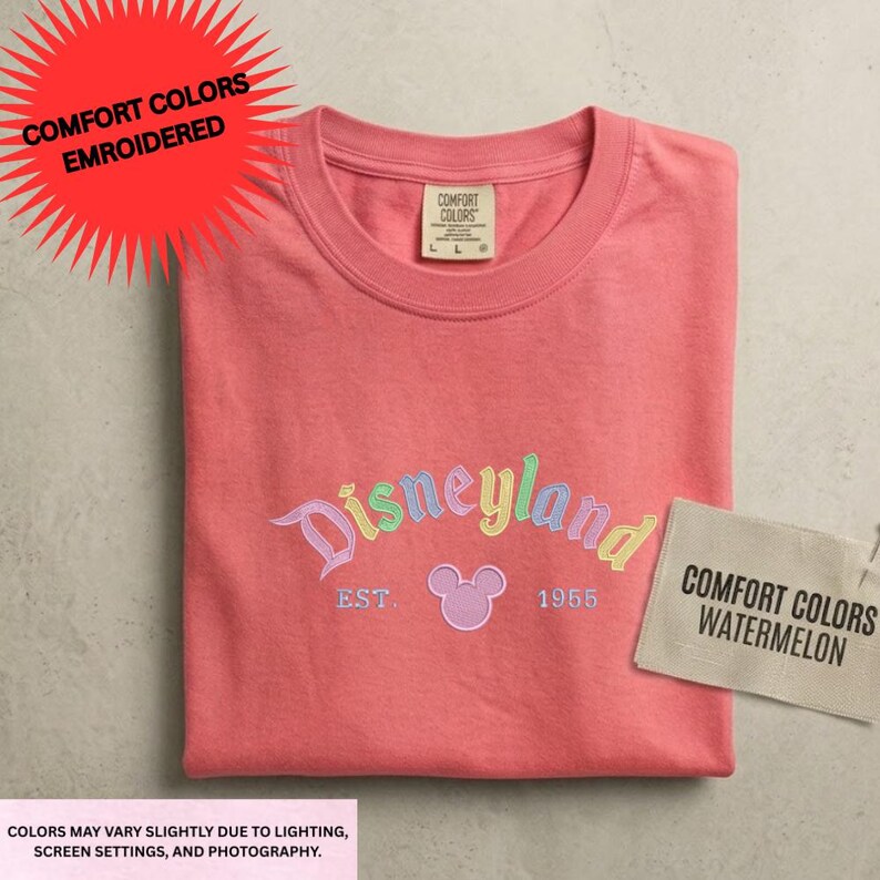 a pink t-shirt with the Disneyland logo and text, along with a tag that says "Comfort Colors" and a label that says "Comfort Colors Watermelon".