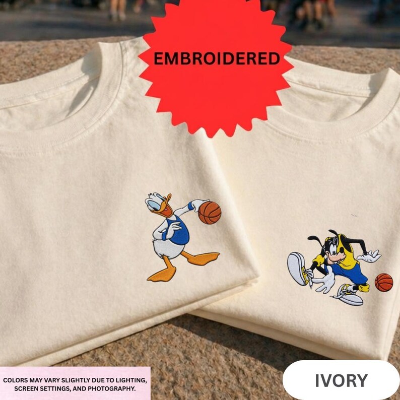 two white t-shirts with cartoon characters printed on them, including a duck and a dog.