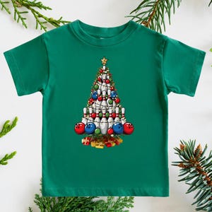 A green t-shirt with a Christmas tree design featuring bowling pins and ornaments.