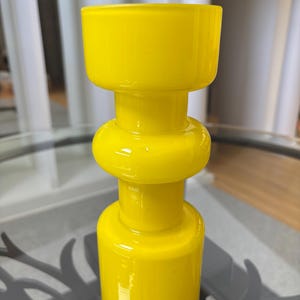 Peut inclure: Un vase en verre jaune vif avec un design unique et empil&eacute;. Le vase pr&eacute;sente une base cylindrique, une section m&eacute;diane arrondie et un large sommet ouvert. La finition brillante refl&egrave;te la lumi&egrave;re, soulignant la couleur vibrante. Id&eacute;al pour la d&eacute;coration int&eacute;rieure.