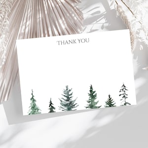 May include: A white card with the text "THANK YOU" printed in black at the top. The bottom of the card features a row of watercolor painted evergreen trees in shades of green.