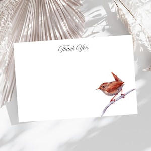 May include: A white card with the words "Thank You" in elegant script. A watercolor illustration of a small brown bird perched on a branch is featured on the card. The card is suitable for sending thank you notes.