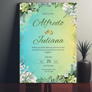 Puede incluir: Tarjeta de guardar la fecha con un fondo de acuarela en tonos azules y verdes. La tarjeta presenta un diseño floral con vegetación y flores blancas. El texto en la tarjeta dice "Save The Date", "Alfredo", "Juliana", "Wishing you both endless joy and love on this beautiful journey as you build your new lives together", "Saturday", "May 25, 2026", "At 07:00 Am", "123 Anywhere St., Any City, ST 12345".