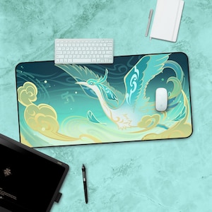 May include: A blue and green mouse mat featuring a stylised image of a bird in flight. The bird is surrounded by clouds and swirls. The mouse mat has a black border.