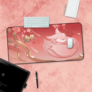 May include: A pink and gold mousepad with a cartoon fox design. The fox is sleeping on a wave with cherry blossoms in the background.