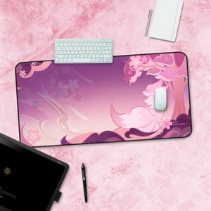 May include: A pink and purple gaming mouse mat with a white keyboard and a white mouse on top. The mouse mat features a pink fox with a cherry blossom tree in the background.