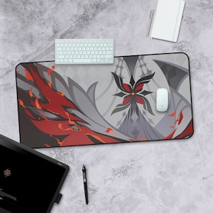 May include: A large, rectangular gaming mouse pad with a black, red, and gray design. The design features a stylized flower with a black center and red petals. The mouse pad is on a gray surface with a white keyboard and a white mouse.