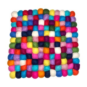 May include: A square, multi-colored felt ball rug. The rug is composed of hundreds of small, round felt balls in a variety of colors, including red, blue, yellow, green, and pink. The balls are arranged in a grid-like pattern.