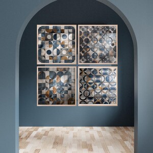 May include: Four framed abstract art prints with geometric patterns in shades of blue, gray, and gold. The artwork is displayed on a dark blue wall, with a wooden floor in the foreground. The prints are square and have a light wood frame.