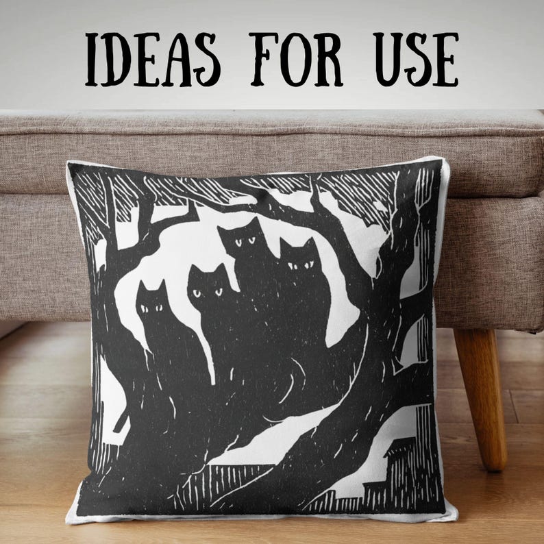 May include: Square throw pillow with a black and white cat design. The pillow features a linocut style illustration of several cats in a tree, with the text "IDEAS FOR USE" above. The pillow is placed on a neutral-colored sofa.