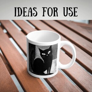 May include: White ceramic mug featuring a black cat illustration with white eyes and whiskers. The mug has a curved handle and the text "IDEAS FOR USE" in black. The cat design is set against a geometric background.