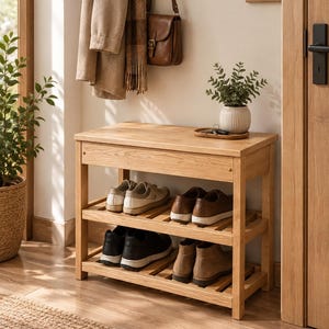 Könnte beinhalten: Eine Schuhbank aus hellem Eichenholz mit zwei Lattenregalen zur Aufbewahrung. Auf der Oberseite befinden sich eine kleine grüne Pflanze in einer gerippten weißen Keramikvase sowie ein Holztablett mit Schlüsseln. Vier Paar Schuhe stehen im Regal.