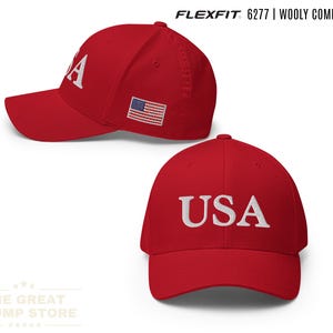 以下が含まれることがあります： 白で刺繍された「USA」が特徴の赤いFlexfit 6277ウーリーコームドキャップ。キャップの側面にはアメリカ国旗が付いています。The Great Trump Storeのロゴが下にあります。「RED」の文字が右下にあります。