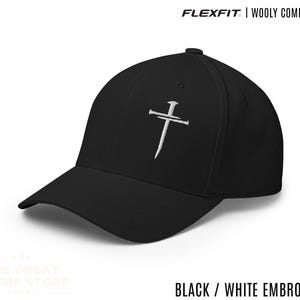 Può includere: Cappellino nero Flexfit in lana pettinata con ricamo bianco di una croce fatta con chiodi. Il cappellino ha una visiera curva e una vestibilità strutturata. Il testo "FLEXFIT | WOOLY COMBED CAP" è in alto. Il testo "BLACK / WHITE EMBROIDERY" è in basso.
