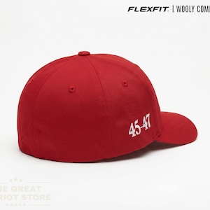 May include: A red baseball cap featuring the text FLEXFIT | WOOLY COMBED CAP at the top and the white embroidered numbers 45-47 on the side. The cap has a structured crown, a curved brim, and a solid red fabric construction throughout the design.