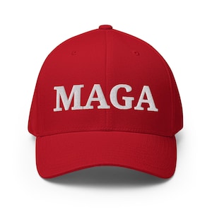 Pode incluir: Boné de beisebol vermelho com as letras brancas bordadas "MAGA" na frente. O boné tem uma aba curva e um ajuste estruturado, adequado para vários tamanhos de cabeça.