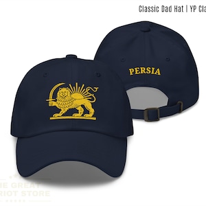 May include: Navy blue Classic Dad Hat with a gold emblem of a lion and sun. The text "PERSIA" is embroidered on the back. The hat is from YP Classics and is available in navy.