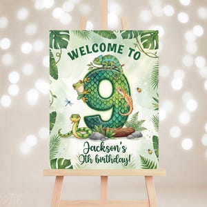 Puede incluir: Un letrero de bienvenida para una fiesta de 9 cumpleaños. El letrero presenta un gran número 9 verde decorado con reptiles e insectos. El texto dice "Bienvenido a" en la parte superior y "¡9 cumpleaños de Jackson!" en la parte inferior.