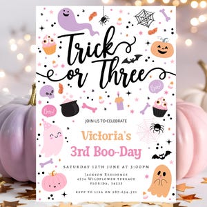 May include: A Halloween-themed invitation with the text "Trick or Three" in black script. The invitation features illustrations of ghosts, pumpkins, spiders, and cupcakes in pastel colors. The invitation is for Victoria's 3rd Boo-Day.