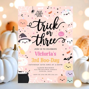 May include: A Halloween-themed invitation with the words "Trick or Three" in black script. The invitation features cute ghost and pumpkin illustrations, along with the text "Victoria's 3rd Boo-Day". The background is light pink.