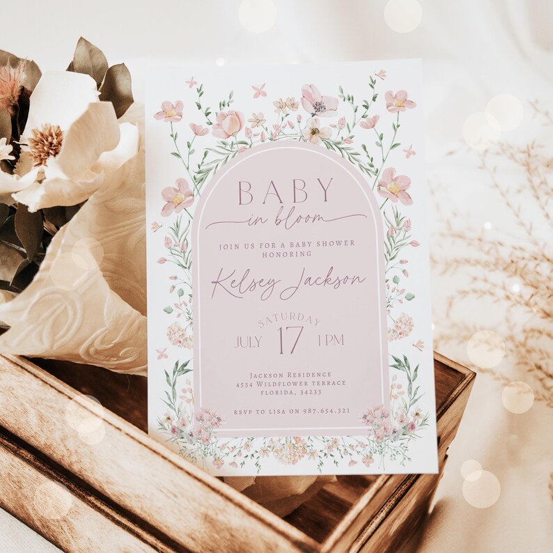 May include: A pink and white floral baby shower invitation with the text "Baby in Bloom" and "Kelsey Jackson". The invitation includes the date and time of the shower, the address, and RSVP information.