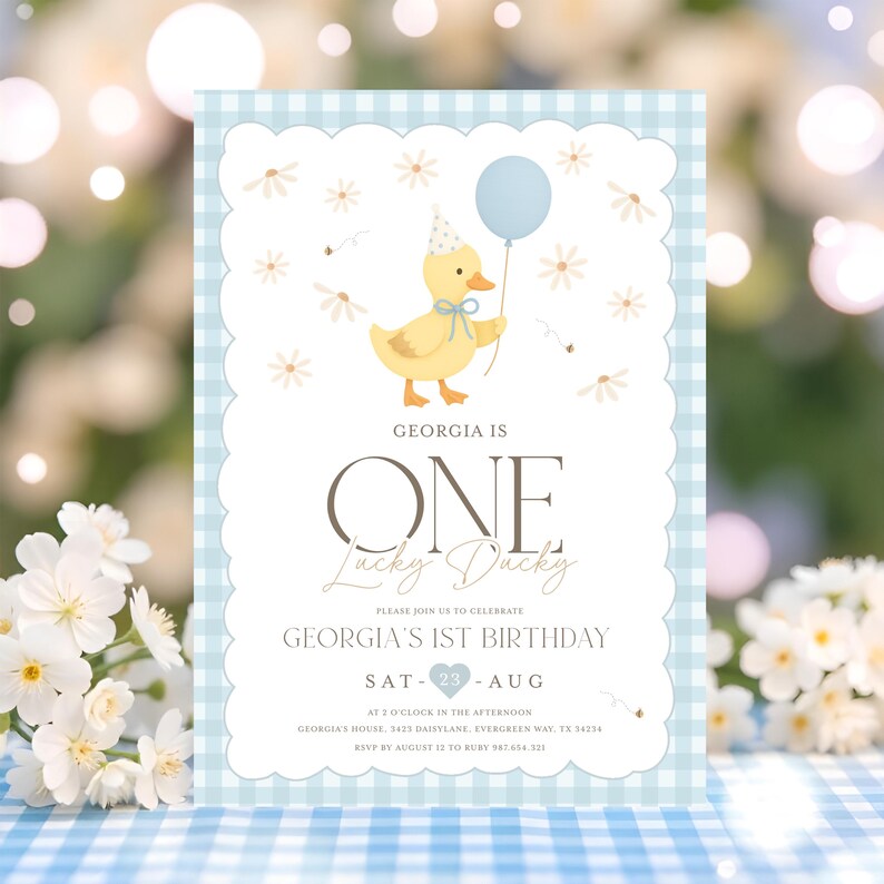 May include: A light blue and white gingham patterned invitation for a first birthday. The invitation features a cartoon duck holding a blue balloon. The text reads "GEORGIA IS ONE Lucky Ducky" and details for the party.