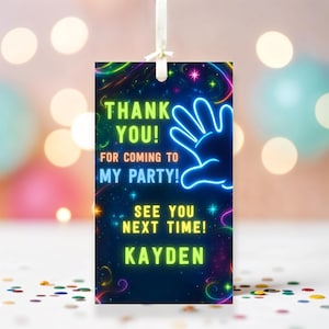 May include: Neon green and blue thank you tag with a glowing handprint and stars on a dark blue background. The text reads "Thank You! For coming to my party! See you next time! Kayden".