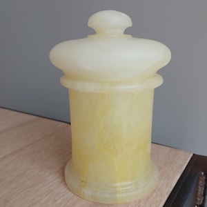 May include: A set of three ceramic mugs with a speckled, matte finish. The mugs are in shades of cream, light gray, and dark gray. Each mug has a simple, minimalist design and a rounded handle.