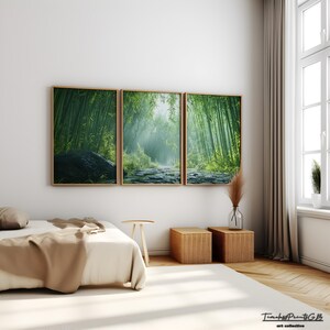 May include: A three-piece set of framed prints depicting a lush green bamboo forest with a path leading through it. The prints are hung on a white wall in a bedroom setting with a bed, side tables, and a window.