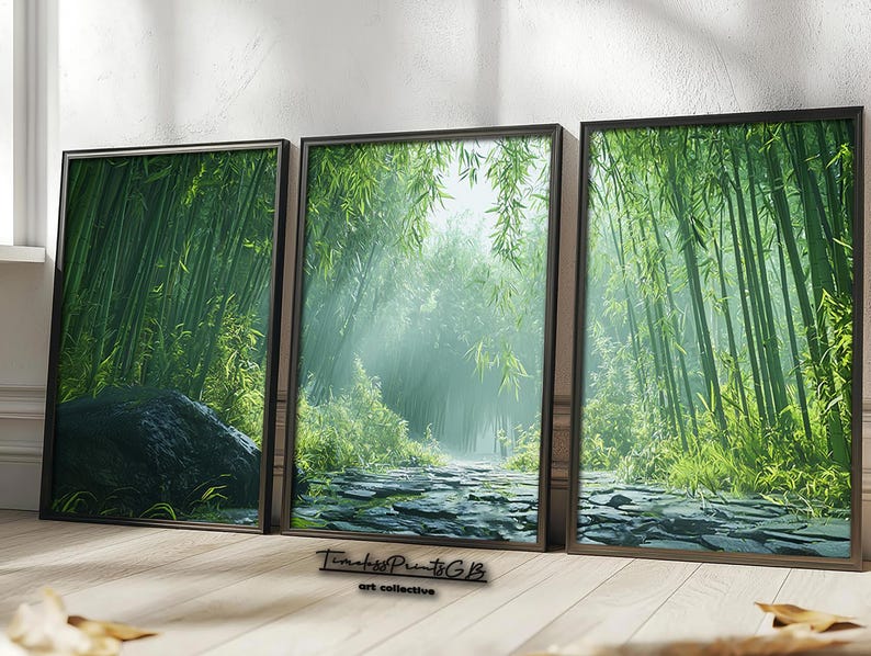 May include: Three framed prints of a lush green bamboo forest with a stone path leading through the center. The prints are in black frames and are hung on a white wall.