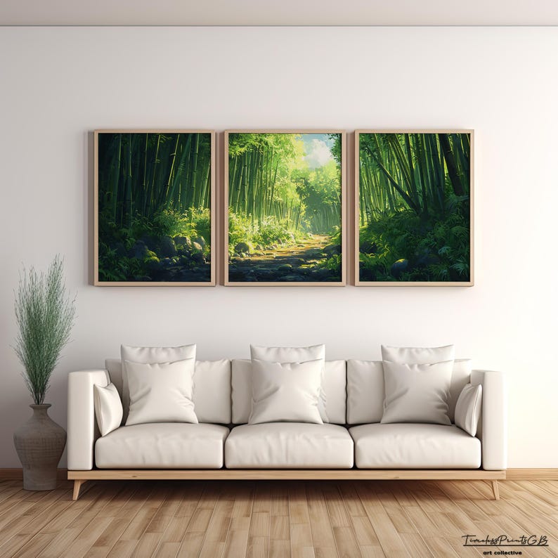 May include: A triptych of framed art prints depicting a lush bamboo forest scene. The artwork features a path winding through the green bamboo, with sunlight filtering through the trees. The frames are a light wood color, and the prints are displayed above a white sofa.