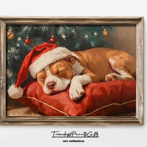 May include: A brown and white dog wearing a red Santa hat sleeps on a red pillow under a Christmas tree with ornaments.