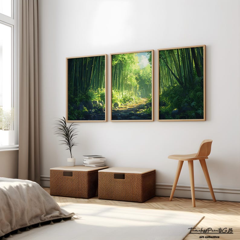 May include: Three framed art prints depicting a lush bamboo forest scene with a path leading through the trees. The prints are displayed above two woven storage ottomans and a wooden chair. The room has a neutral color palette with natural light.