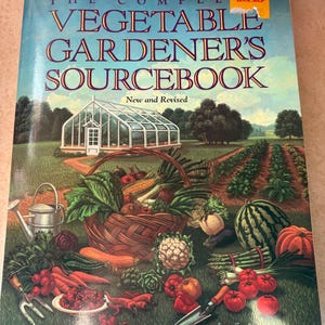 May include: A book cover titled "The Complete Vegetable Gardener's Sourcebook" by Duane and Karen Newcomb. The cover features a garden scene with a greenhouse, rows of vegetables, and a basket overflowing with produce. A Borders Book Shop sticker is visible.