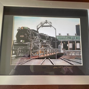 May include: A framed black and white illustration of a large black steam locomotive with the number 2723 on the side. The locomotive is on a track and is in a train yard. The image is signed "Doug 777 & Dowell".
