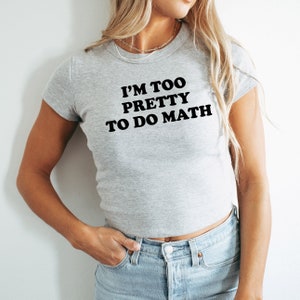May include: A gray cropped t-shirt with the text "I'm too pretty to do math" in black.