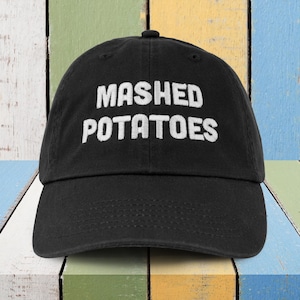 May include: A black baseball cap with white embroidered text that reads "MASHED POTATOES".