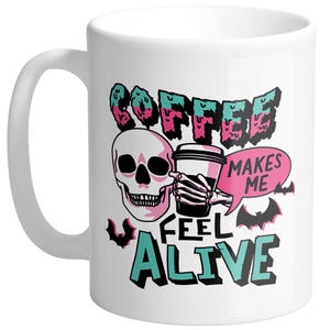 May include: White ceramic coffee mug with a black handle featuring a skull graphic and the text "COFFEE MAKES ME FEEL ALIVE" in teal, pink, and black. Includes a coffee cup and bat illustrations.