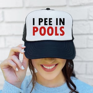 May include: A black and white trucker hat with a white front panel and black mesh back. The front panel has the text "I PEE IN POOLS" in black and red letters.