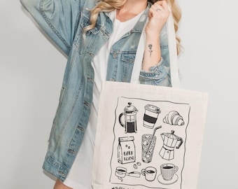 May include: A natural canvas tote bag featuring black line drawings of coffee-related items, including a French press, coffee cup, croissant, and a bag of dark roast coffee. The text "MAYBE COFFEE IS ADDICTED TO ME" is printed at the bottom.