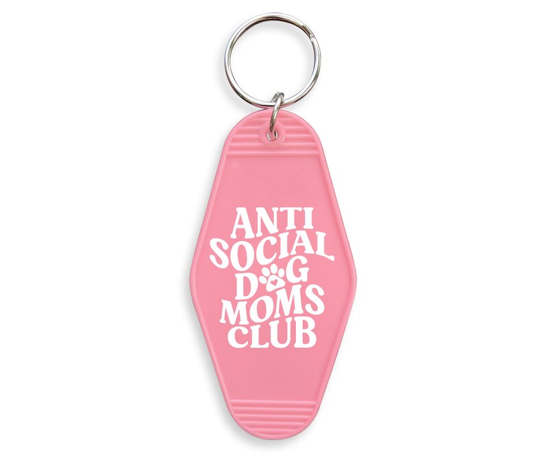 May include: Pink motel key chain with the text "Anti Social Dog Moms Club" in white lettering.
