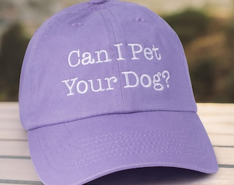 May include: A purple baseball cap with white embroidered text that reads "Can I Pet Your Dog?"