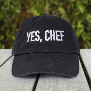 May include: A black baseball cap with white embroidery that reads "YES, CHEF".