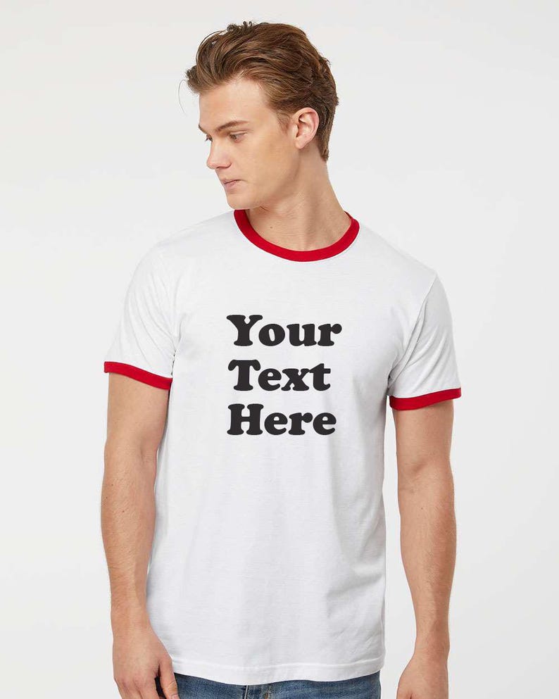May include: White t-shirt with a red ringer and the text "Your Text Here" printed in black.