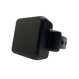 May include: A black 3D printed wristband with a square-shaped device attached to it.