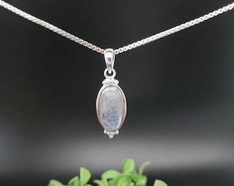 May include: A silver chain necklace with a silver pendant featuring a light blue oval moonstone.