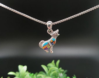 May include: A silver necklace with a small, colorful wolf pendant. The wolf is made of sterling silver and inlaid with turquoise, coral, and other gemstones. The necklace is 18 inches long and has a lobster clasp.