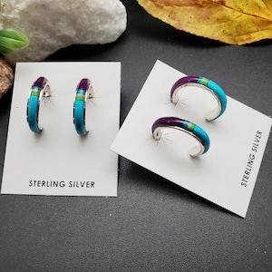 Puede incluir: Un par de pendientes de aro de plata de ley con incrustaciones de turquesa, morado y verde. Los pendientes se muestran en una tarjeta blanca con el texto "Sterling Silver".