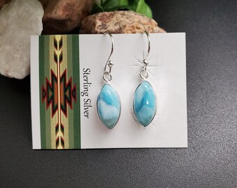 May include: Sterling silver earrings with blue and white marbled gemstone drops. The earrings are on a white card with the text "Sterling Silver" printed on it.